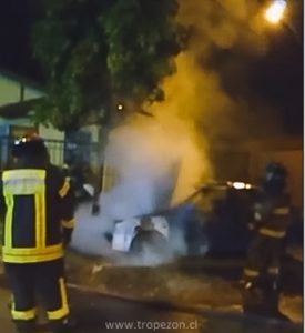 Bomberos apagando el fuego de un automóvil