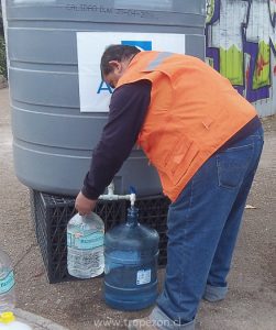 Personal de Aguas Andinas entregando agua a vecinos en General Bonilla con el Salitre