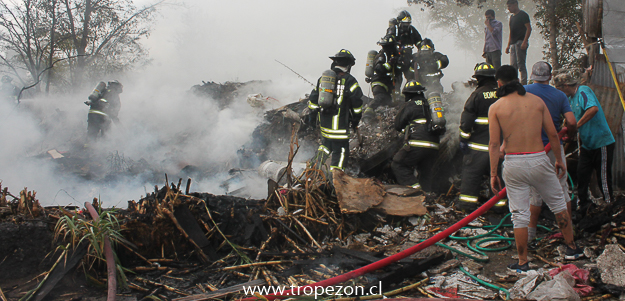 Bomberos y jóvenes del sector controlando el incendio
