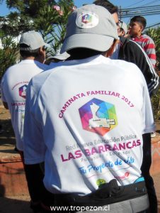 Jóvenes estudiantes exhibiendo gorros y poleras alusivas al evento que les fueron entregadas por los organizadores