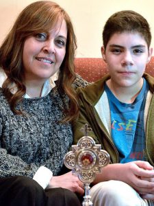 Verónica junto a su hijo Sebastián y la reliquia del Padre Faustino Miguez